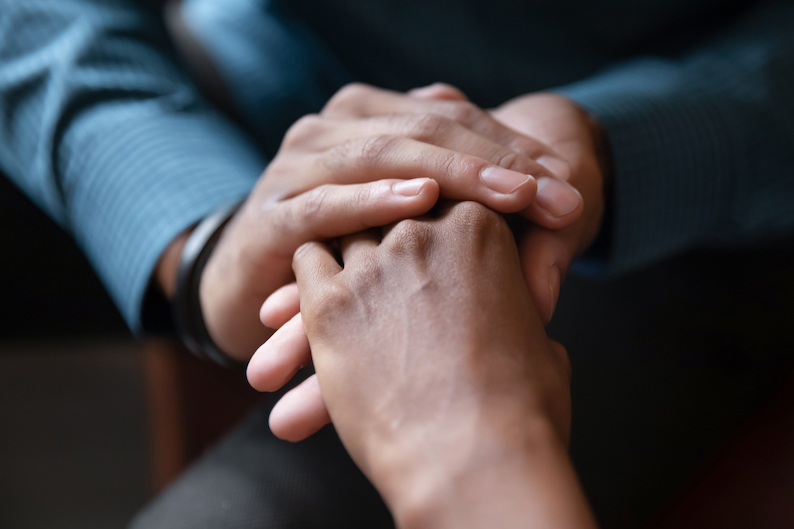 Close,Up,Of,Young,Couple,Hold,Hands,Talking,Sharing,Secrets